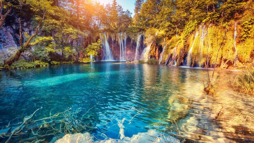 Turquoise Lake Sunlit Waterfalls